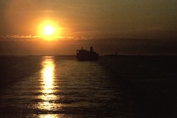 Sonnenaufgang mit Fährschiff achtern